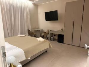 a bedroom with a bed and a desk and a television at Lolli Boutique Suite Al Massimo Palermo Centro in Palermo +33 photos