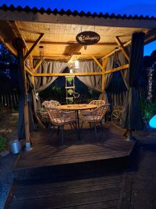 a wooden deck with a table and chairs under a pergola at Haus am Vogelsang in Hannoversch Münden