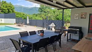 a patio with a table and chairs and a grill at Villa Velaris Mostar in Mostar