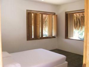 een slaapkamer met 2 witte bedden en 2 ramen bij Casa Carey in Palomino