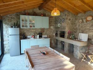 a kitchen with a wooden table and a refrigerator at Casa da Pinha in Ponte da Barca