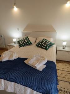 a bed with two pillows and towels on it at Casa da Pinha in Ponte da Barca