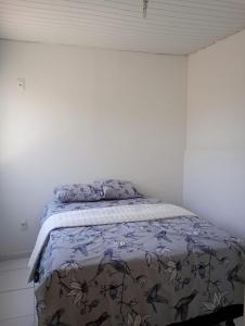 a bed in a white room with a blanket on it at Boêmia carioca in Rio de Janeiro