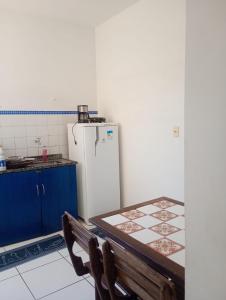 a kitchen with a table and a white refrigerator at Boêmia carioca in Rio de Janeiro