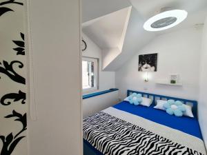 a small bedroom with a blue and white bed at Apartments Sandra in the historical center of the city in Supetar