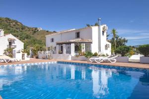 a villa with a swimming pool in front of a house at Casa de Suenos in Comares