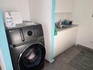 a washing machine in a kitchen next to a sink at La Casita de Ceiba in Ceiba