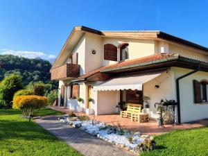 a house with a porch and a lawn at B&B La Pecora Nera in Belluno
