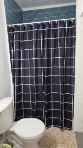a bathroom with a toilet and a shower curtain at La Casita de Ceiba in Ceiba +13 photos