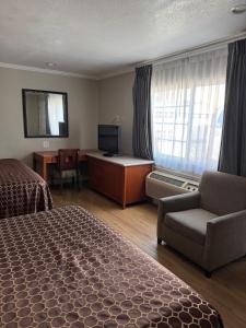 a hotel room with a bed and a couch and a television at Castaway Motel in Orange