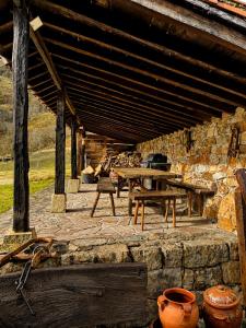 a patio with a wooden table and a stone wall at Laguna de Valfría in Fresneda