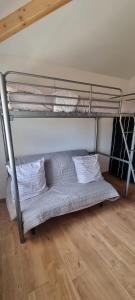 a bunk bed with two white pillows on a wooden floor at La Grange in Champagne-de-Blanzac