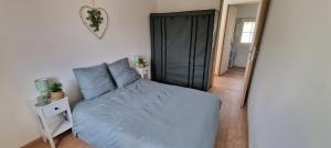 a bedroom with a bed and a black closet at La Grange in Champagne-de-Blanzac