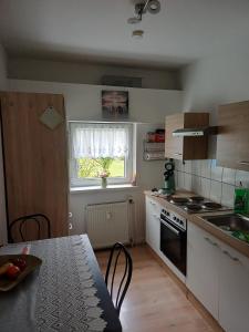 a kitchen with a table and a stove and a window at Ferienwohnung Wusterwitz in Wusterwitz