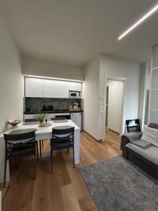 a kitchen and living room with a table and chairs at Corona dei Sogni Appartamento moderno vicino Ospedale e Centro in Novara
