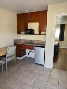 a kitchen with a counter and a sink and a table at Castaway Motel in Orange