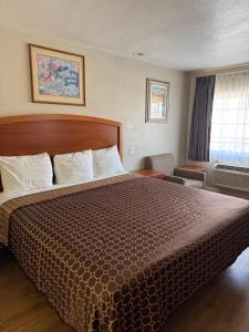 a hotel room with a large bed and a window at Castaway Motel in Orange