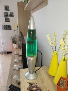 a green and silver lamp on a table with vases at Ferienwohnung mit Meerblick in Povile