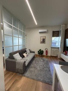 a living room with a couch and a table at Corona dei Sogni Appartamento moderno vicino Ospedale e Centro in Novara