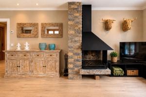 a living room with a fireplace and a tv at CaL QuEROL Llivia 2 piscina, 8 pax, 2 baños y parking in Llivia