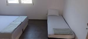 a bedroom with two beds and a window at Vila Ali in Krivoglavci