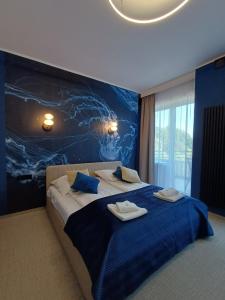 a bedroom with a large bed with towels on it at Hotel Dom Marynarza in Gdynia