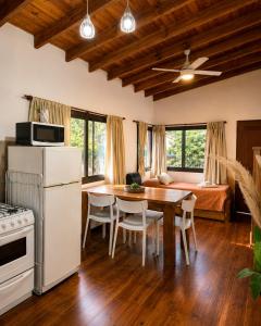 a kitchen and dining room with a table and chairs at Algarrobos del Mirador in Santa Rosa de Calamuchita