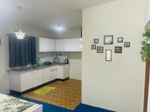 a kitchen with white cabinets and a counter top at Hillcrest Terraces Bhurban in Rāwāt
