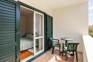 a room with a table and chairs and a bedroom at Villa Bunta in Sutivan