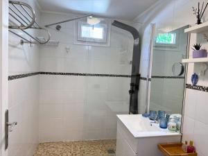 a white bathroom with a sink and a shower at Charmant T2 à 5 minutes de l'Aéroport d'Orly in Paray-Vieille-Poste +13 photos