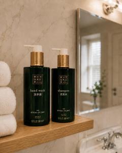 two bottles of soap sitting on a shelf in a bathroom at Powerscourt Arms Hotel in Enniskerry