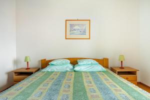 a bedroom with a bed with two nightstands and two lamps at Villa Bunta in Sutivan