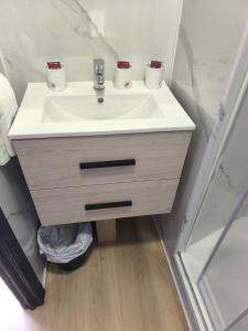 a bathroom sink with two cups on top of it at Hostal Cafetería La Rotonda in Ourense