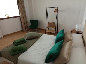 a large bed with green pillows in a room at VT Varadero in Fisterra