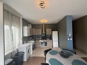 a kitchen with a table and a kitchen with appliances at Appartement Cuvier in Roubaix