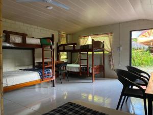 a room with three bunk beds and a table and chairs at Grand Selva Lodge & Tours in Tena