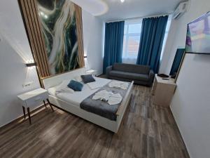 a small bedroom with a bed and a couch at LA PLAYA - Studiouri pe plaja cu sezlong inclus in Eforie Nord