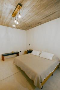 a bedroom with a large bed and a wooden ceiling at Casa Gulal in Teotitlán del Valle