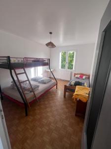 a room with two bunk beds and a table at Le Gîte de Saint Romans in Saint-Romans-lès-Melle