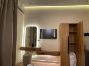 a room with a television on a wall with a desk at Latina City in Cairo