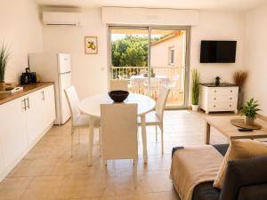 a kitchen and living room with a table and a dining room at Horizon Bleu Canet in Canet-en-Roussillon