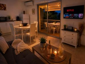 a living room with a couch and a table and a kitchen at Horizon Bleu Canet in Canet-en-Roussillon