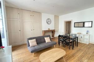 a living room with a couch and a table at Appartement Centre-ville Dole in Dole