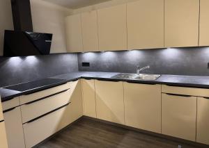 a kitchen with white cabinets and a sink at ESER - Haus am Vogesenblick in Bad Bellingen +9 photos