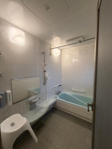 a bathroom with a bath tub and a sink at Rabbit Island Inn in Mihara