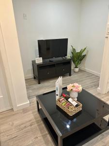 a living room with a coffee table and a tv at Modern Cozy Home W Free Parking- Close to Downtown & Beach in Victoria