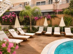a patio with lounge chairs and a swimming pool at Bella Rose Apart Hotel, Alanya in Alanya
