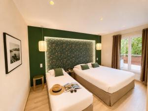 a hotel room with two beds and a window at Hôtel Le Mistral in Porto-Vecchio +84 photos