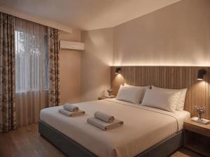 a bedroom with a large bed with towels on it at Bella Rose Apart Hotel, Alanya in Alanya +57 photos