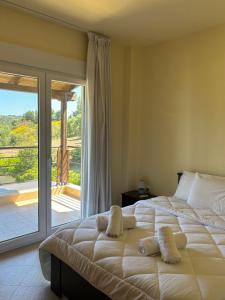 a bedroom with a large bed and a sliding glass door at Villa Beauty in Paliouri +14 photos